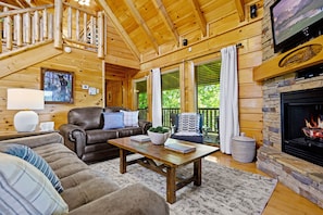 Open concept living room with electric fireplace with new leather sofas. 