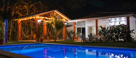 Rancho amaquero y piscina iluminados de noche