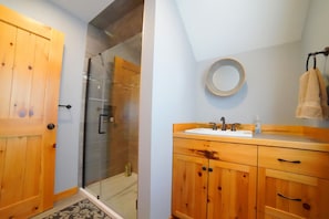 The recently renovated bathroom enjoys a large walk-in shower and a cozy vanity.