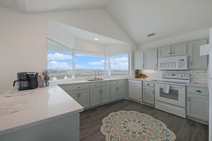 Well-stocked kitchen with cooking tools, cookware and seasoning/condiments.