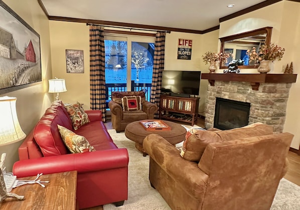 The warm and inviting living room has a gas fireplace and access to patio.