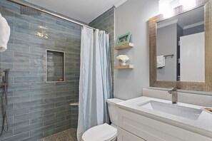 The brand new walk-in shower has gorgeous tile, a bench, rainwater shower head and separate sprayer, plus a niche to store your shower products.