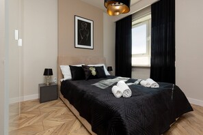 Bedroom with a double bed, elegant black bedding, and framed artwork on the wall.
