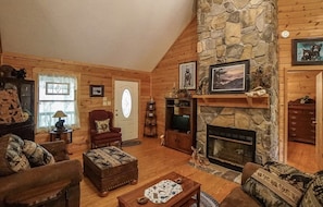 Large living area with plentiful seating, flatscreen tv with YouTube TV, DVD player, and a gas fireplace