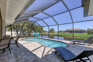 Lanai with lounge chairs, chairs, a sitting area, a 48 inch TV,and a pool.