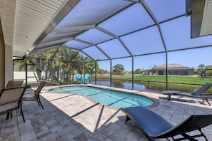 Lanai with lounge chairs, chairs, a sitting area, a 48 inch TV,and a pool.
