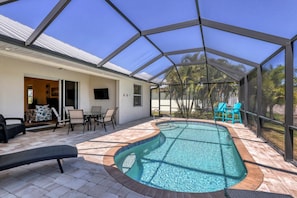 Lanai with lounge chairs, chairs, a sitting area, a 48 inch TV,and a pool.