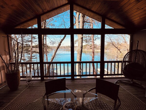 Screened porch with Sunset Lake view, table for 6, fridge, fan & string lights.