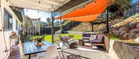 Private backyard patio with covered dining table and chairs