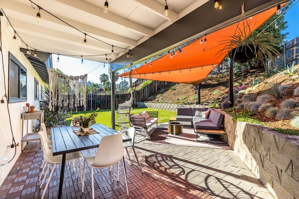 Private backyard patio with covered dining table and chairs