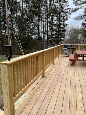 Front deck, solar lights, picnic table and grill. 