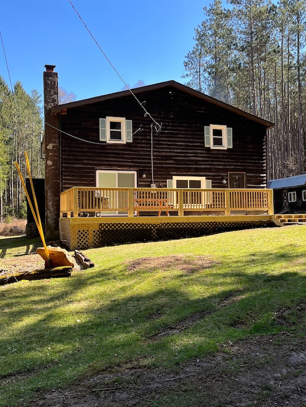 Front view with large front deck, picnic table and grill. 