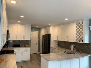 Deluxe kitchen with top-shelf, new appliances including Keurig coffee machine. 