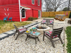 The vast outdoor space includes firepit, hot tub, and rocking sun loungers.