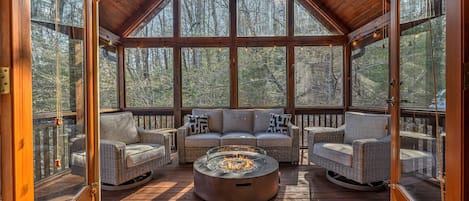 Upper level screened porch with conversation seating and gas fire pit. 