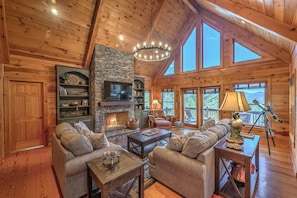 Main level living room with a view, game cabinet, telescope, wood fireplace 