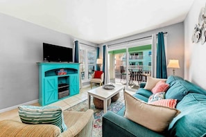Living area with balcony access and views of the ocean