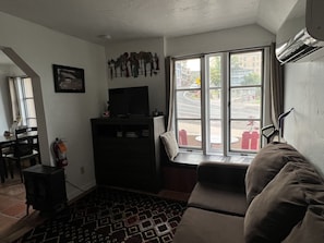 View of living room from the bed. Pull out couch, tv, and dresser.