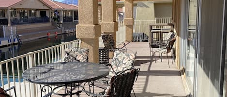 Gated covered patio w/  seating , tall bar and overhead lighting.