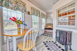 Enclosed sunroom on the front of the cottage with electric fire place.