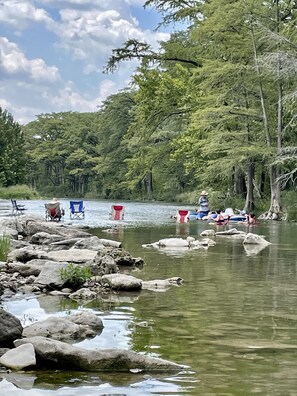 guest enjoying their day sitting in the river as floaters come by