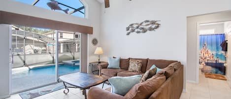 Family room overlooking private pool, open to kitchen, perfect for relaxing.