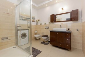 The bathroom's contemporary design includes fresh towels and a hairdryer. 