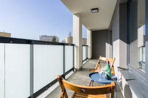 Spacious balcony with outdoor furniture.