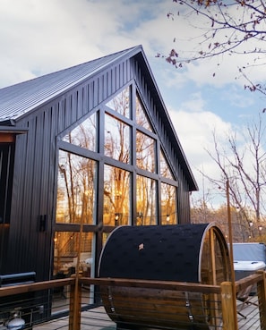 A 6-person Scandinavian barrel sauna overlooking the lush forest on property.