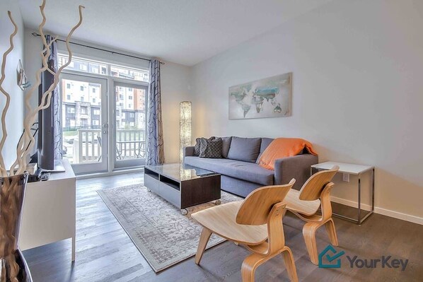 Main floor living area with seating for your whole group. The couch pulls out into a bed and the smart TV also has cable. Just off the living space you have a patio and small grassed area. 