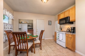 Kitchen includes a fridge, dine-in table, Microwave, coffee, sink, and gas stove
