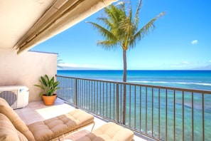 Spacious oceanfront balcony with plush loungers, swaying palms, and endless views of turquoise island waters LOK-B203