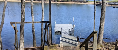 A ladder is located on the floating dock. Porch swing located on left.