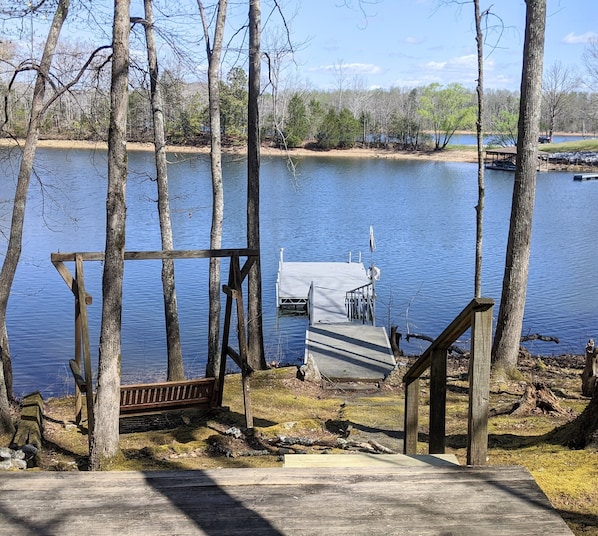 A ladder is located on the floating dock. Porch swing located on left.