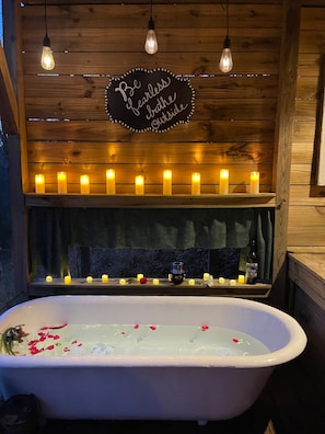 The antique tub provides a relaxing and private romantic setting.