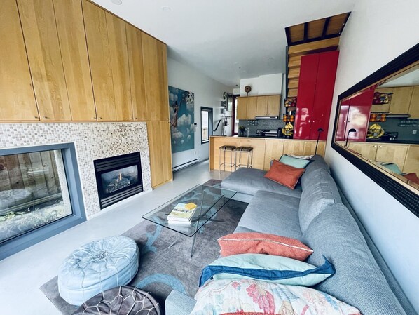 The bright, modern living room opens up onto a private back deck w/ hot tub. 