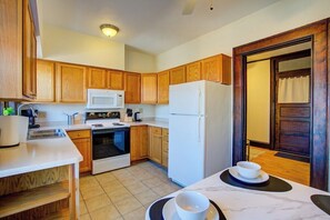 Kitchen with stove, sink, refridgerator, countertops, cabinets and dining table