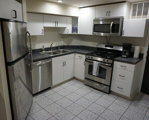 Cook or enjoy take out in this full kitchen with all the basic essentials (pots, pans, plates, bowls, cups, silverware, knives, plastic cutting boards, and a coffee pot). 