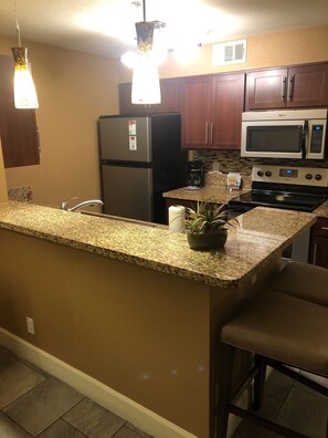 Full kitchen with microwave, dishwasher, plates, utensils, coffee maker and more