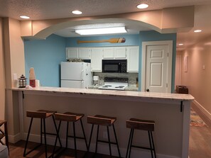 Full kitchen with granite countertop and bar area