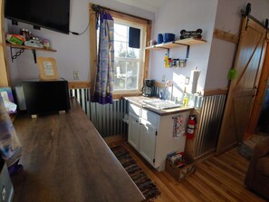 Kitchenette with TV, microwave, toaster, hot plates, coffee and mini fridge