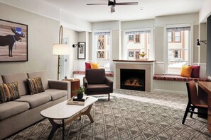 Living room features a sleeper sofa, fireplace, small desk, and flat-screen TV.