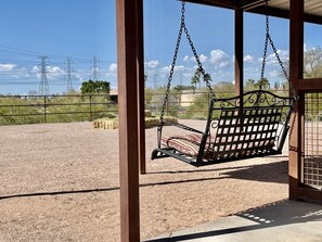 Escape the chaos of everyday life as you unwind on our comfortable bench swing, delighting in the picturesque views of the surrounding desert landscape from the shade of our horse stables.