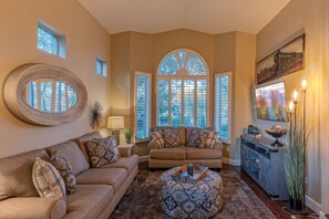 Formal yet comfortable living room with arched window is at the front of the home.