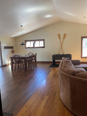 Open kitchen, dining, and living room with a fuse-ball table.
