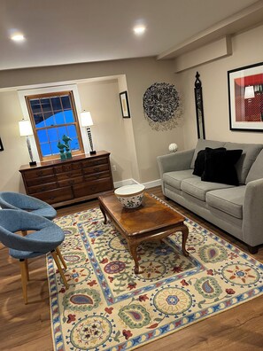Downstairs sitting area with queen sofa sleeper and bedding.