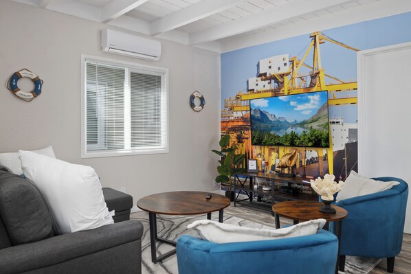 Cozy living room with nautical touches and a striking port-themed accent wall.