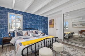 Stylish bedroom with a blue nautical accent wall and mirrored closet.