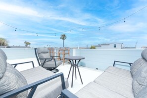 The rooftop deck looks out onto the boulevard and beach beyond. It includes ample seating and fun, outdoor lights for al fresco evenings.
                