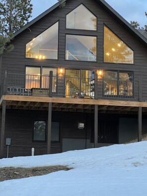Cozy cabin nights with glowing lights and peaceful pine views.